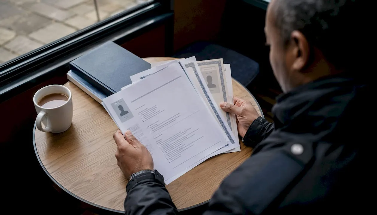 Hands reviewing UK security CV documents