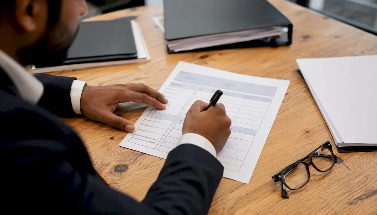 Hands completing UK shortlisting scorecard