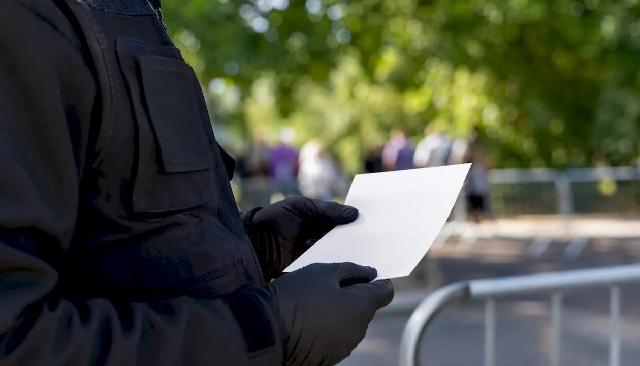 UK security officer holding identity document