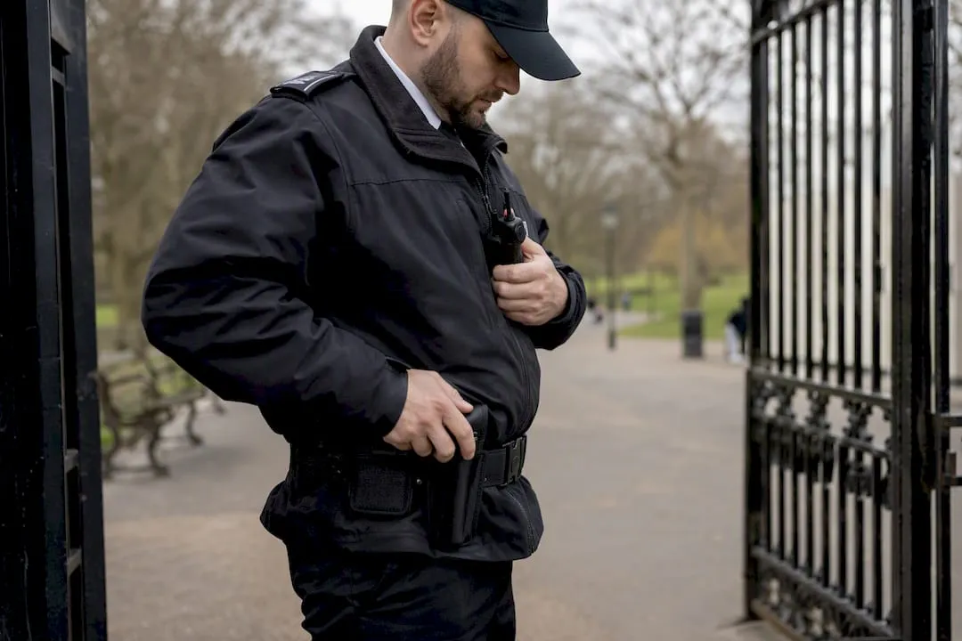 UK security guard adjusting radio outdoors