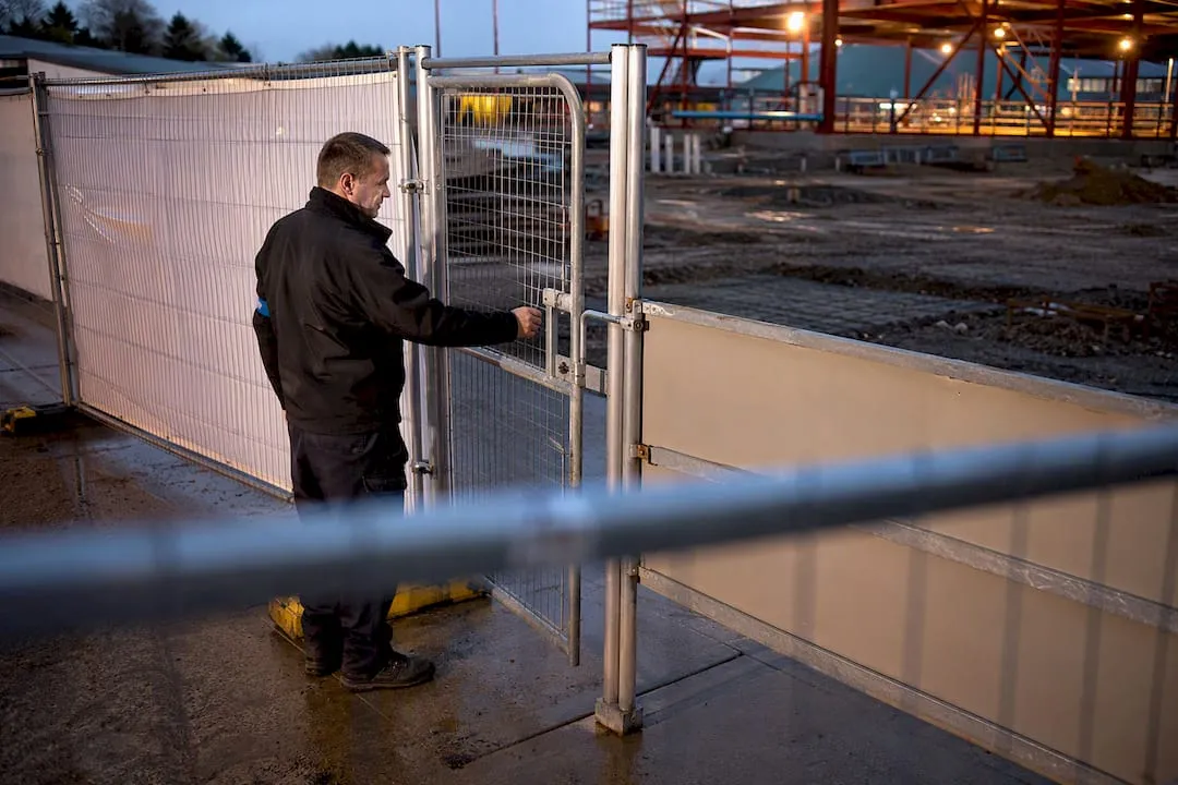 UK security operative inspecting construction site gate